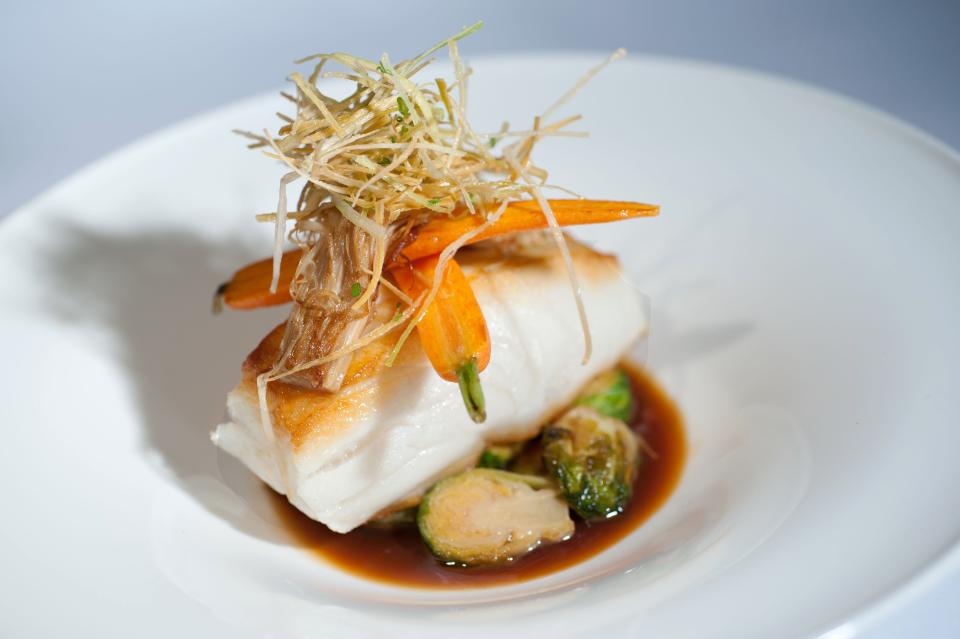 PB Catch's Chilean sea bass is topped with glazed carrot and served over caramelized Brussels sprouts.