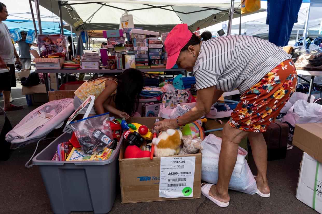 Inhabitants rummage through boxes of donated children toys at a distribution location in a neighborhood of Lahaina, Hawaii, USA, 13 August 2023. (EPA)
