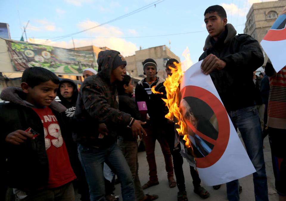 Palestinians burn a poster of the former Prime Minister Ariel Sharon in Khan Younis, southern Gaza Strip, Saturday, Jan. 11, 2014. Sharon was loathed by many Palestinians as a bitter enemy who did his utmost to sabotage their independence hopes — by leading military offensives against them in Lebanon, the West Bank and Gaza and a settlement drive on the lands they want for a state. Sharon died Saturday, eight years after a debilitating stroke put him into a coma. He was 85. (AP Photo/Hatem Moussa)