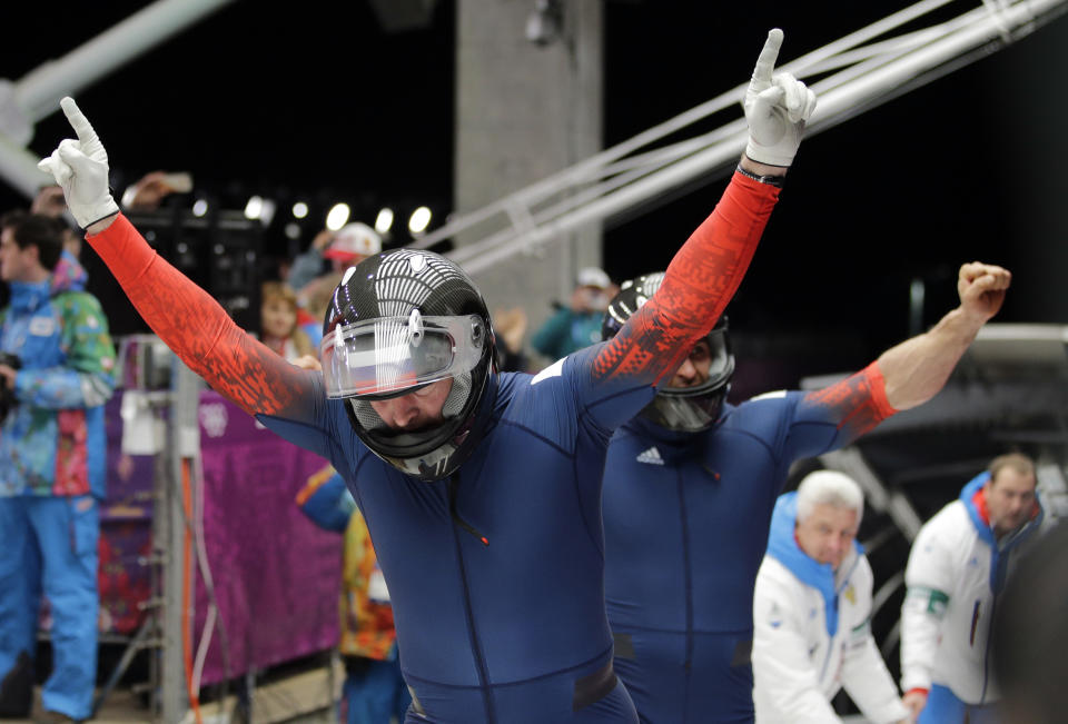 The team from Russia RUS-1, piloted by Alexander Zubkov and brakeman Alexey Voevoda, celebrate their gold medal run during the men's two-man bobsled competition at the 2014 Winter Olympics, Monday, Feb. 17, 2014, in Krasnaya Polyana, Russia. (AP Photo/Jae C. Hong)