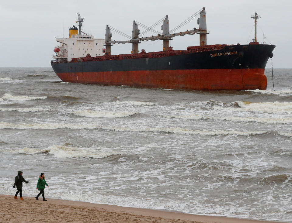 <p>In der litauischen Küstenstadt Klaipėda spazieren Ausflügler über einen Strandabschnitt. Im Hintergrund ist der Frachter Ocean Crown zu sehen, der vor einigen Tagen dort aufgelaufen ist. (Bild: REUTERS/Ints Kalnins) </p>