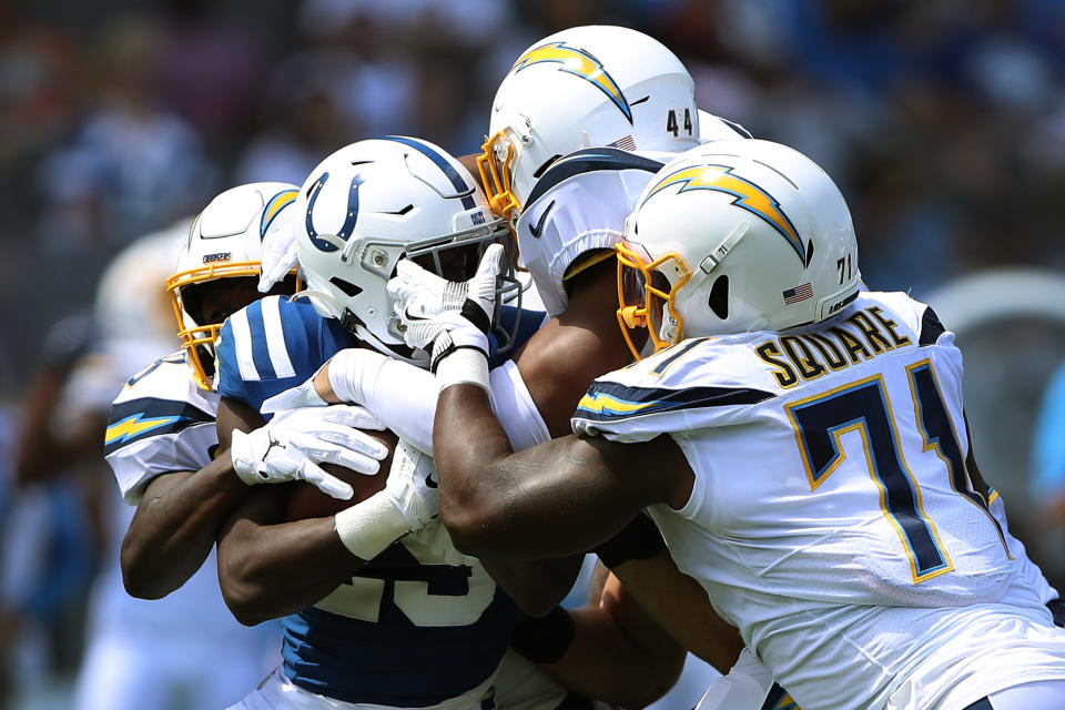 Marlon Mack #25 of the Indianapolis Colts is tackled by Kyzir White #44, Thomas Davis #58, and Justin Jones #93 of the Los Angeles Chargers during the first half of a game at Dignity Health Sports Park on September 08, 2019 in Carson, California. (Photo by Sean M. Haffey/Getty Images)