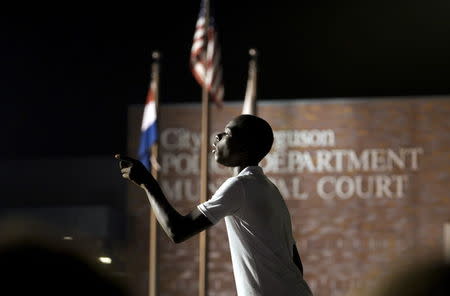 A protester yells at police stationed outside the police department in Ferguson, Missouri August 8, 2015. REUTERS/Rick Wilking