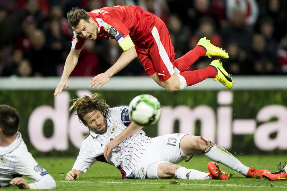 Swiss defender Stephan Lichtsteiner, top, fights for the ball with Latvia's defender Kaspars Gorkss, during their World Cup Group B qualifying soccer match at the stade de Geneve stadium, in Geneva, Switzerland, Saturday, March 25, 2017. (Jean-Christophe Bott/ Keystone via AP)