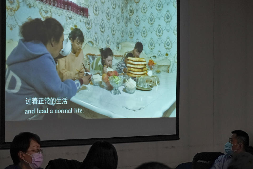 People wearing face masks watch a screen showing the living of ethnic Uighur in Xinjiang, during a press conference related to Xinjiang issues at the Ministry of Foreign Affairs office in Beijing, Monday, Feb. 1, 2021. An official from China's far west Xinjiang region accused former U.S. Secretary of State Mike Pompeo on Monday of trying to undermine Beijing's relations with President Joe Biden by declaring China's actions against the Uighur ethnic group a 