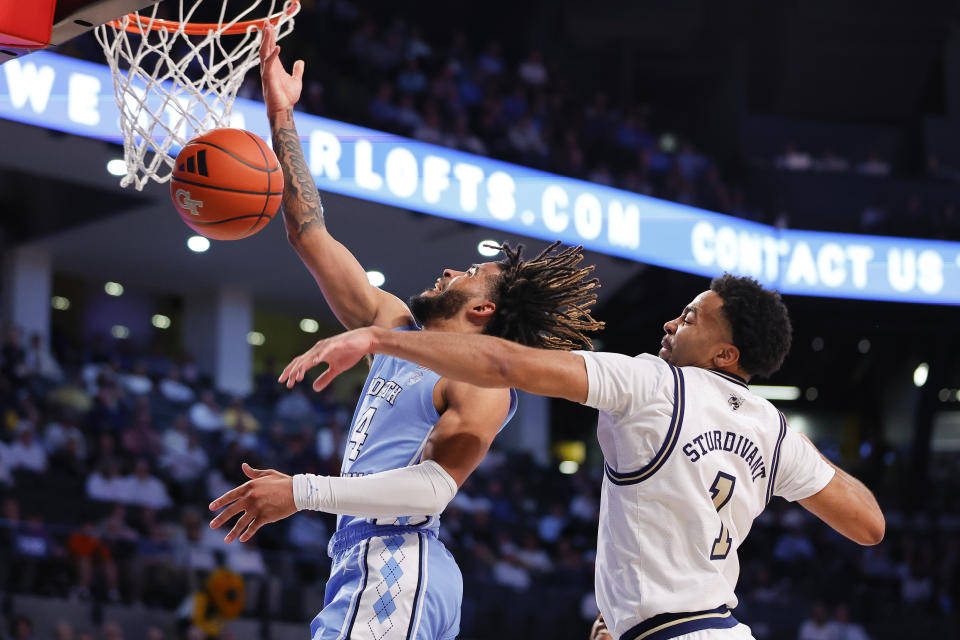 Georgia Tech guard Kyle Sturdivant, right, blocks a shot from North Carolina guard RJ Davis (4) during the first half of an NCAA college basketball game Tuesday, Jan. 30, 2024, in Atlanta. (AP Photo/Alex Slitz)