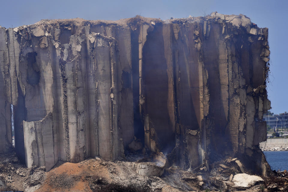 Smoke rises from the north block silos which were damaged during the August 2020 massive explosion in the port, in Beirut, Lebanon, Thursday, July 28, 2022. Emmanuel Durand, a French civil engineer who volunteered for the Lebanese government-commissioned team of experts says it is inevitable that the north block going to collapse. It's only just a matter of time. (AP Photo/Hussein Malla)