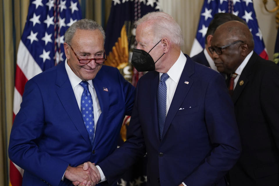 President Joe Biden shakes hands with Senate Majority Leader Chuck Schumer of N.Y., after signing the Democrats' landmark climate change and health care bill in the State Dining Room of the White House in Washington, Tuesday, Aug. 16, 2022. At back right is Rep. James Clyburn, D-S.C. (AP Photo/Susan Walsh)