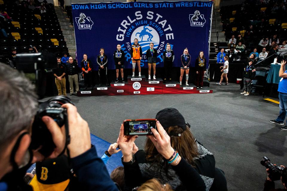 Charles City's Lilly Luft stands atop the podium after scoring a decision at 130 pounds in the finals of the Iowa Wrestling Coaches and Officials Association girls state wrestling tournament Jan. 22, 2022, at Xtream Arena in Coralville.