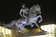 The statue titled Rumor's of War by artist Kehinde Wiley gets fully unveiled after the tarp covering the statue got stuck for a while at the Virginia Museum of Fine Arts in Richmond, Va., Tuesday, Dec. 10, 2019. The monumental bronze sculpture of a young black man astride a galloping horse was unveiled Tuesday, set to be permanently installed in Virginia's capital city, not far from the Confederate monument it mimics. (AP Photo/Steve Helber)