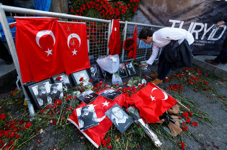 FILE PHOTO: A man places flowers at the entrance of Reina nightclub, which was attacked by a gunman, in Istanbul, Turkey January 3, 2017. REUTERS/Murad Sezer/File Photo