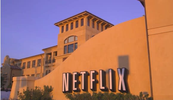 A photo of Netflix's headquarters in Los Gatos, California, featuring the company logo on a stucco wall.