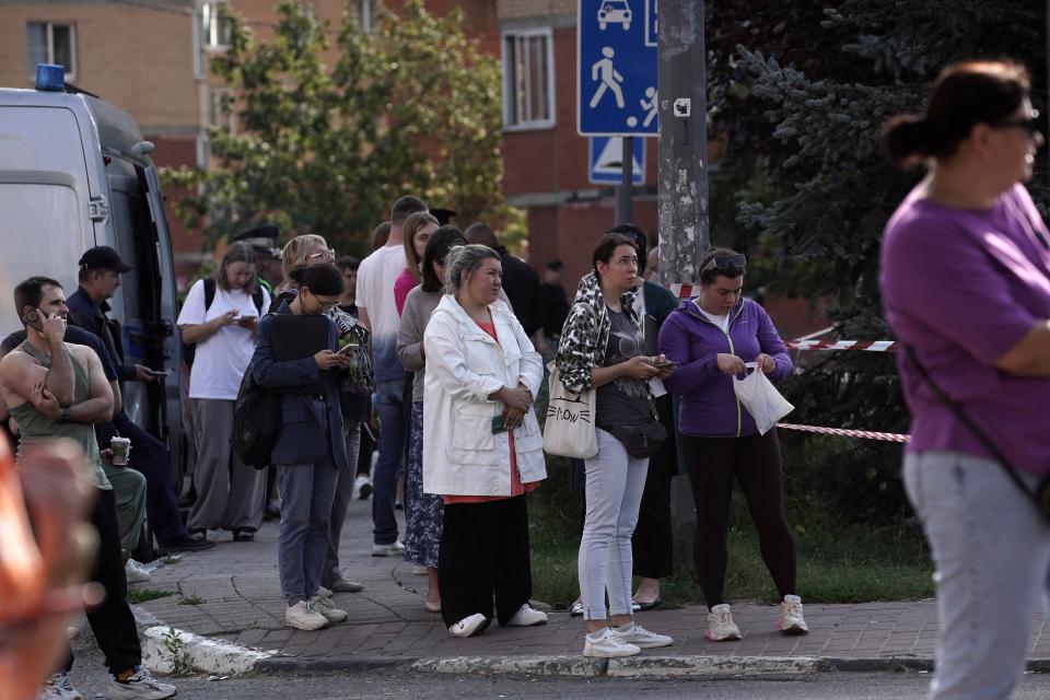 People gather outside of a damaged residential building following a drone attack in Ramenskoye in the Moscow region (AFP via Getty Images)