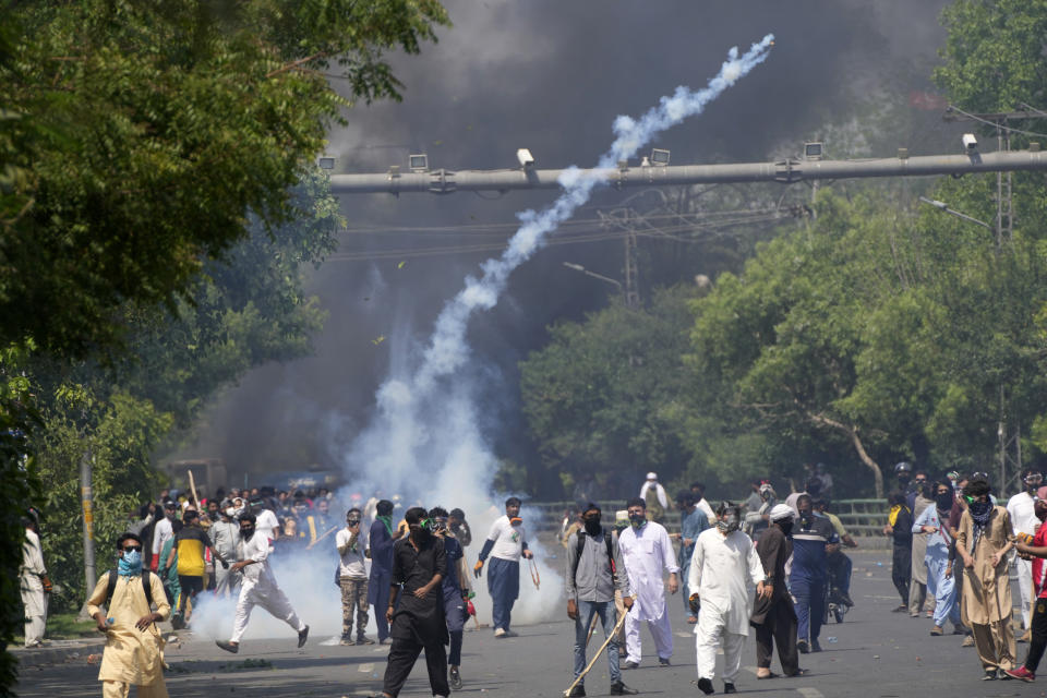 Police fire tear gas to disperse supporters of Pakistan's former Prime Minister Imran Khan protesting against the arrest of their leader, in Lahore, Pakistan, Wednesday, May 10, 2023. Khan can be held for eight days, a court ruled Wednesday, a day after the popular opposition leader was dragged from a courtroom and arrested on corruption charges, deepening the country's political turmoil. (AP Photo/K.M. Chaudary)