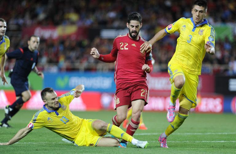 Spain's midfielder Isco (R) vies with Ukraine's defender Vyacheslav Shevchuk (L) and Ukraine's defender Yevhen Khacheridi (R) during the EURO 2016 qualifier football match at the Ramon Sanchez Pizjuan stadium in Sevilla on March 27, 2015