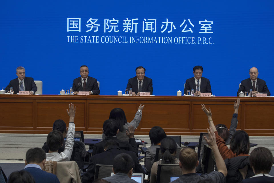 Shohrat Zakir, chairman of China's Xinjiang Uighur Autonomous Region, center, waits for questions during a press conference in Beijing on Monday, Dec. 9, 2019. (AP Photo/Ng Han Guan)