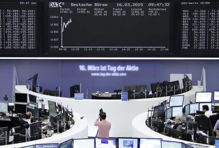 Traders work at their screens in front of the German share price index DAX board at the stock exchange in Frankfurt March 16, 2015. REUTERS/Stringer/Remote