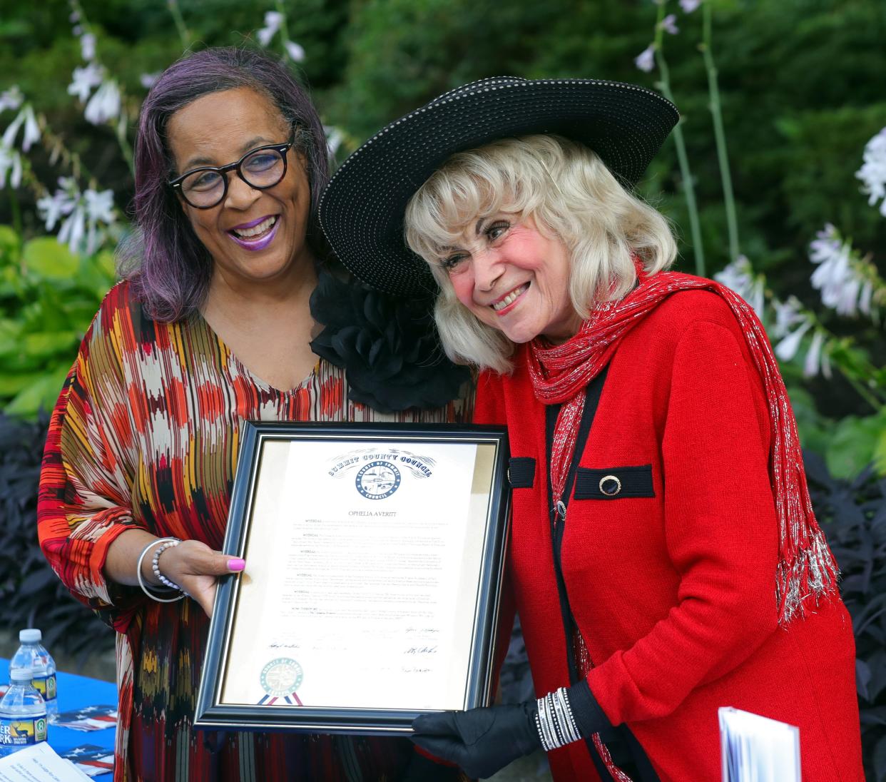 Summit County councilwoman Veronica Sims, left, presents a commendation to local author and former Akron NAACP President Ophelia Averitt on Wednesday during a ceremony outside the Harold K. Stubbs Justice Center in Akron,