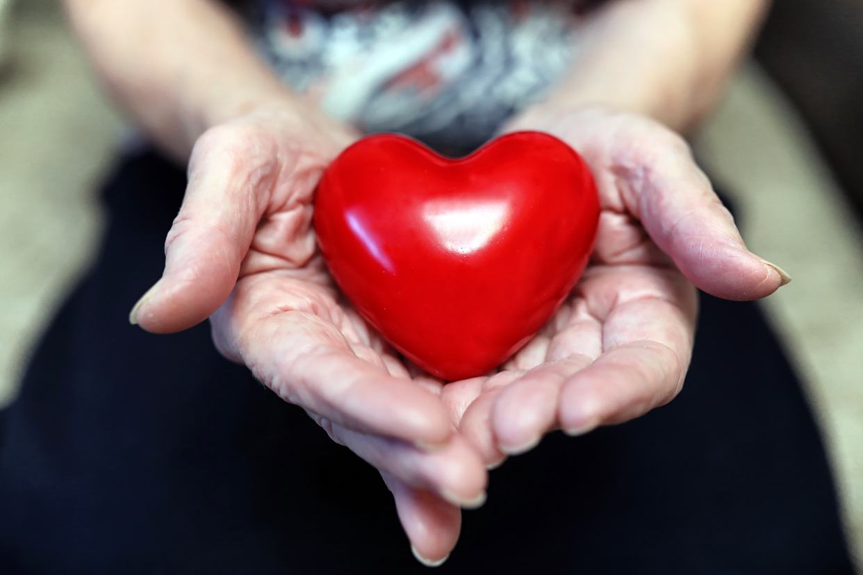 Senior woman hands holding a heart