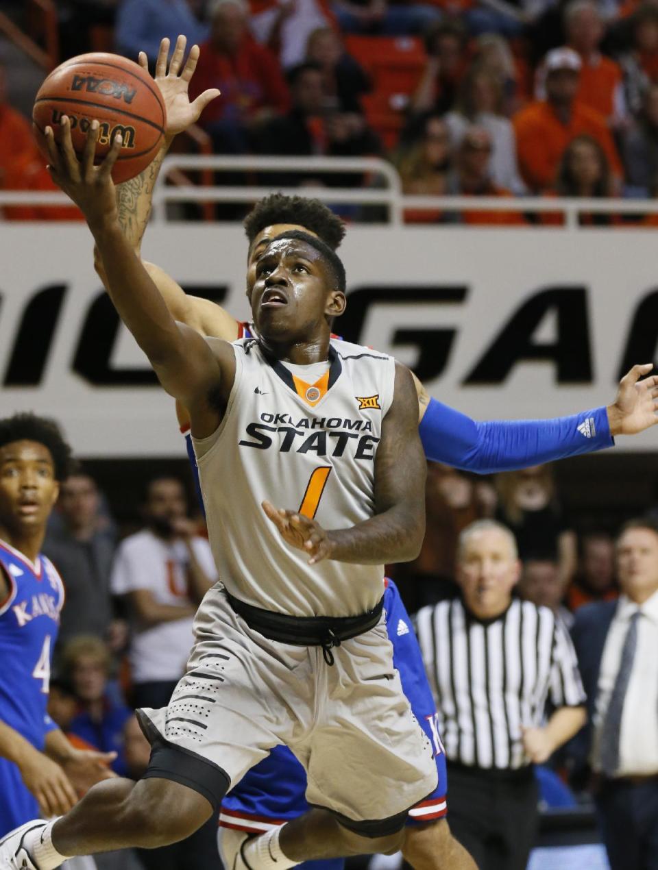 Oklahoma State guard Jawun Evans (1) shoots in front of Kansas guard Frank Mason III, rear, in the first half of an NCAA college basketball game in Stillwater, Okla., Saturday, March 4, 2017. (AP Photo/Sue Ogrocki)