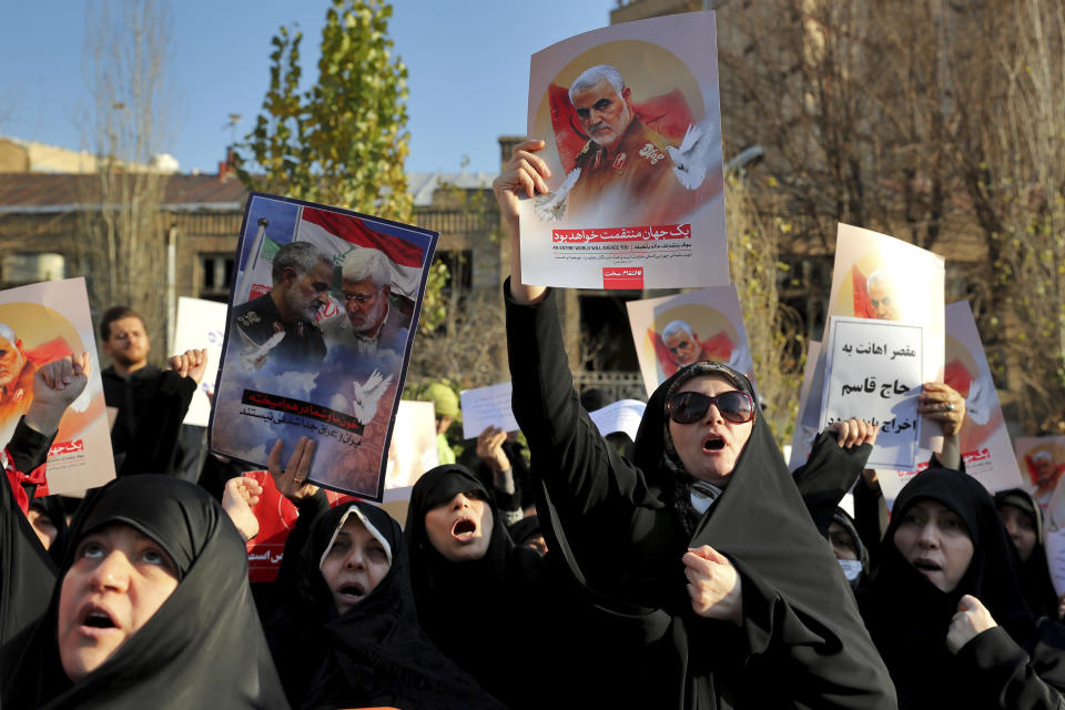 Protesters chant slogans while holding up posters of Gen. Qassem Soleimani during a demonstration in front of the British Embassy in Tehran, Iran, Sunday, Jan. 12, 2020. A candlelight ceremony late Saturday in Tehran turned into a protest, with hundreds of people chanting against the country's leaders — including Supreme Leader Ayatollah Ali Khamenei — and police dispersing them with tear gas. Police briefly detained the British ambassador to Iran, Rob Macaire, who said he went to the Saturday vigil without knowing it would turn into a protest. (AP Photo/Ebrahim Noroozi)