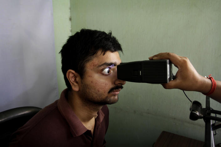 FILE- In this May 16, 2012 file photo, an Indian man gets his retina scanned to register for Aadhar, India's unique identification project, in Kolkata, India. A U.S.-based private cybersecurity company said Wednesday, Sept. 22, 2021, it has uncovered evidence that an Indian media conglomerate, a police department and the agency responsible for the country's national identification database have been hacked, likely by a state-sponsored Chinese group. (AP Photo/Bikas Das, File)