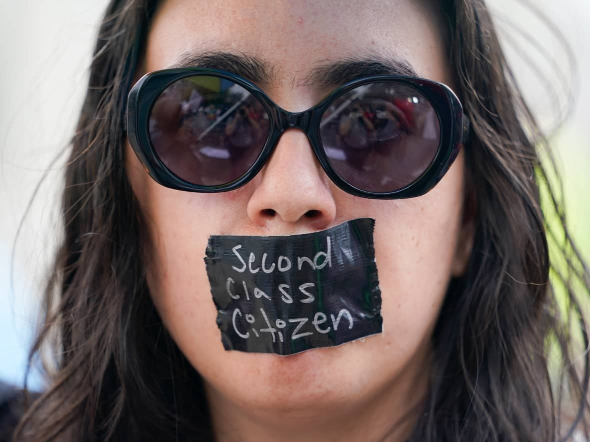 A abortion-rights activist is seen protesting outside the U.S. Supreme Court building on Friday — the same day the top court ended constitutional protections for abortion that had been in place nearly 50 years. (Jacquelyn Martin/The Associated Press - image credit)