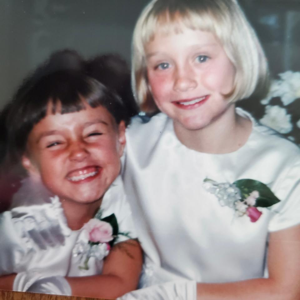 Annika Olson, right, poses with her sister at ages 8 and 6 respectively, when they served as flower girls in a family friend’s wedding.