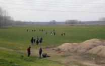 A group of migrants walk through the Turkish-Greek border in a village near the border city of Edirne