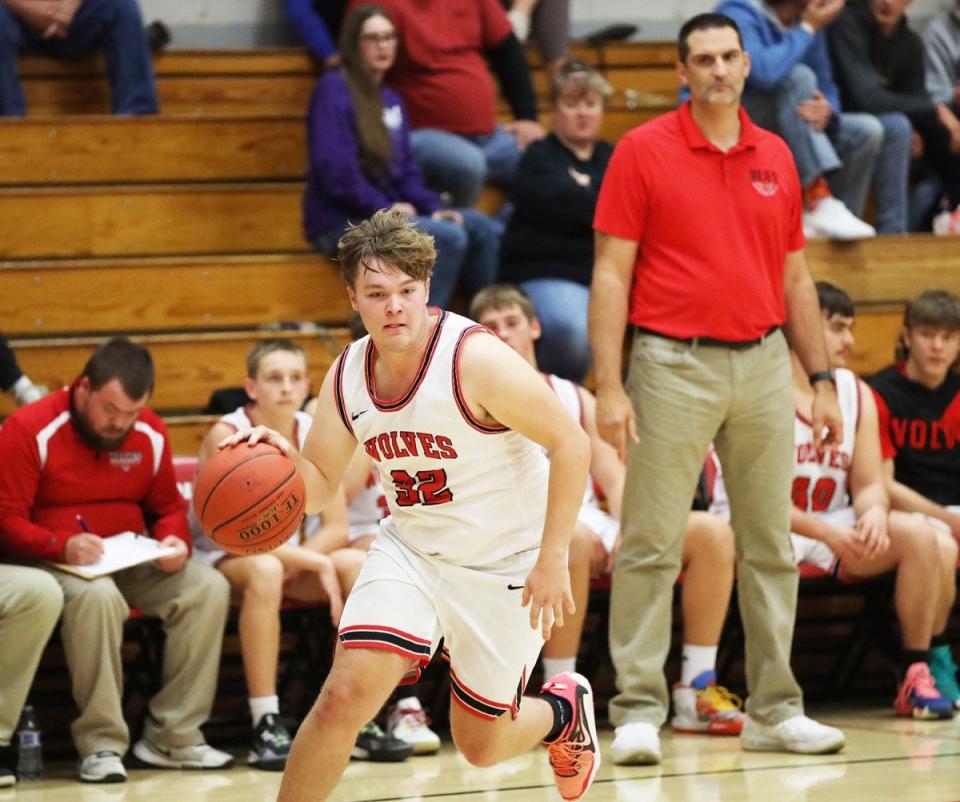 Winfield-Mt. Union’s Andrew Brown drives to the basket as Winfield-Mount Union head coach Klay Edwards looks on.