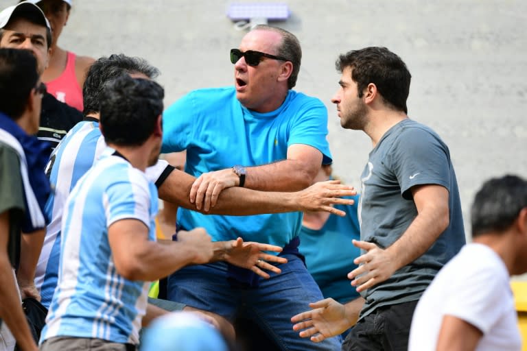 A man tries to separate an Argentina fan fighting with another fan during the men's second round singles tennis match between Argentina's Juan Martin Del Potro and Portugal's Joao Sousa on August 8, 2016