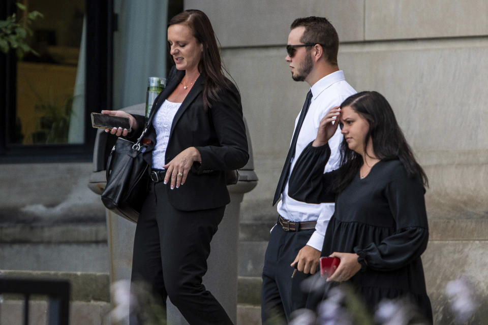 Trevor Gray, 18, center, and defense attorney Jessica Mainprize-Hajek, left, exit the Genesee County Circuit Court, Tuesday, Aug. 3, 2021 in Flint, Mich., after Gray, MarkSekelsky, 19, and Mikadyn Payne, 19, were sentenced to probation for their part in a 2017 rock-throwing incident that killed a motorist on Interstate 75 after spending more than three years in custody while their case was stuck in court. (Isaac Ritchey/The Flint Journal via AP)