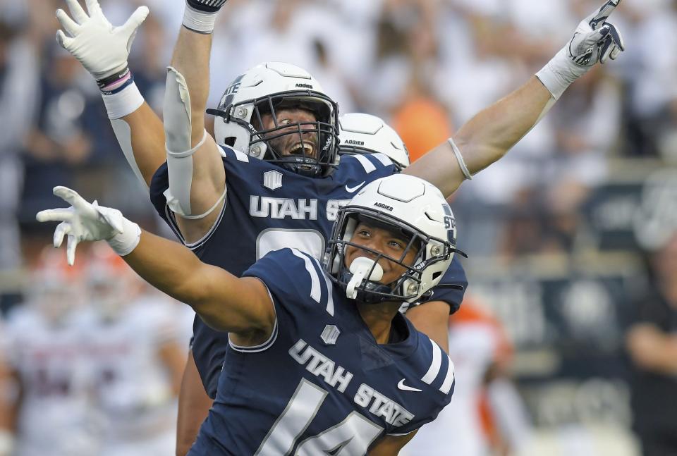 Utah State linebacker Bronson Olevao Jr. (14) and defensive end Paul Fitzgerald celebrate after Idaho State fumbled during a game on Sept. 9, 2023, in Logan, Utah. | Eli Lucero, The Herald Journal via Associated Press