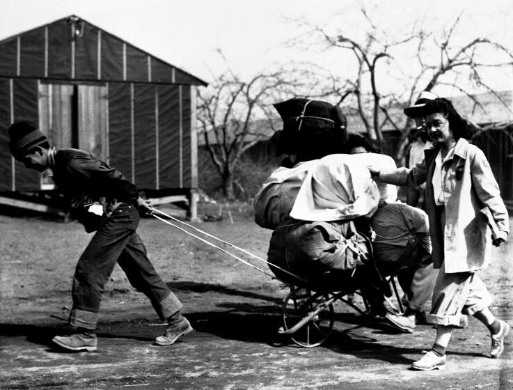 FILE - In this June 19, 1942 file photo, Japanese evacuees move into a war relocation authority center in Manzanar, Calif. Roughly 120,000 Japanese immigrants and Japanese-Americans were sent to desolate camps that dotted the West because the government claimed they might plot against the U.S. (AP Photo/File)