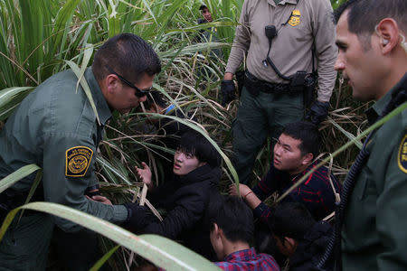 Border patrol agents apprehend immigrants who illegally crossed the border from Mexico into the U.S. in the Rio Grande Valley sector, near McAllen, Texas, U.S., April 3, 2018. REUTERS/Loren Elliott