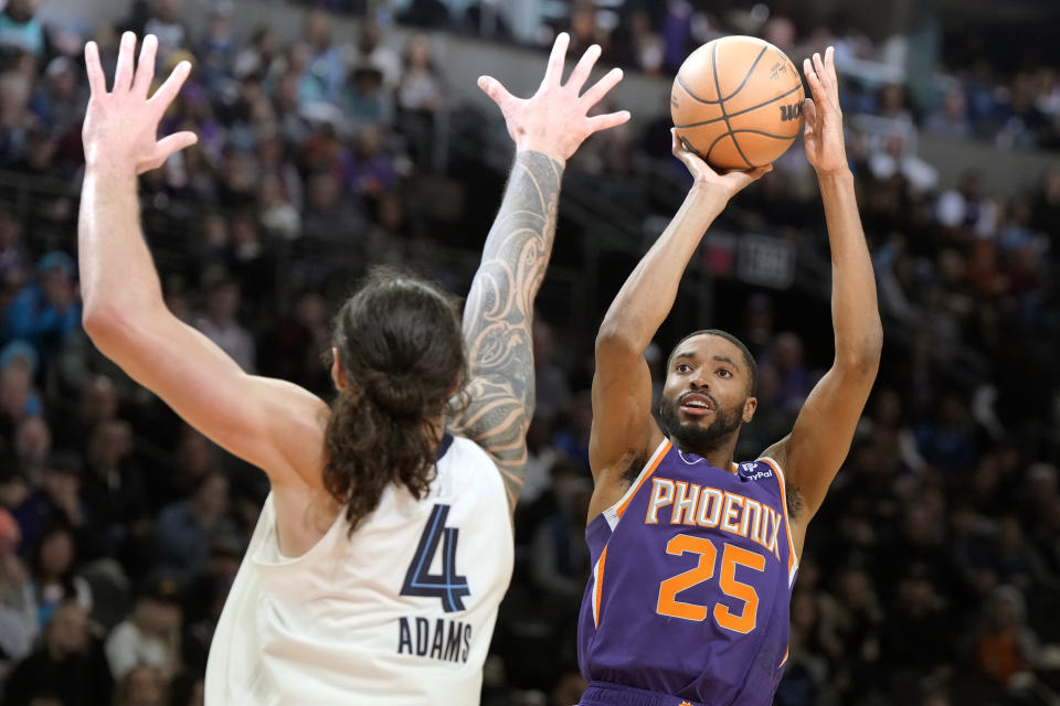 Phoenix Suns forward Mikal Bridges, right, shoots over Memphis Grizzlies center Steven Adams (4) during the second half of an NBA basketball game, Sunday, Jan. 22, 2023, in Phoenix. (AP Photo/Rick Scuteri)