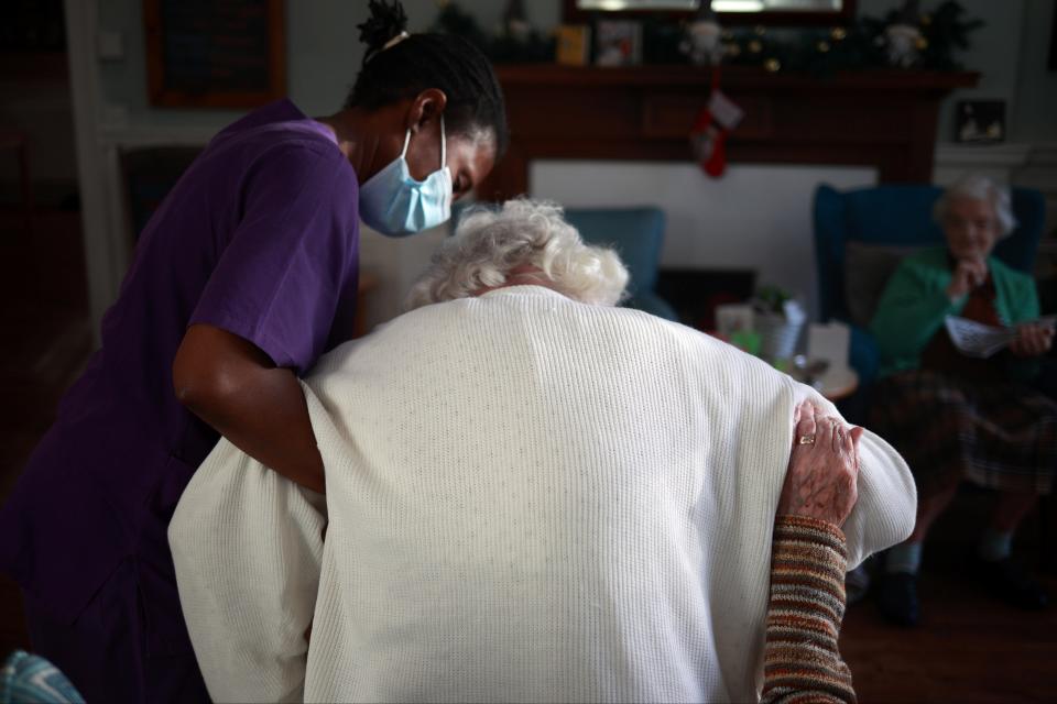 A care worker assists a resident REUTERS