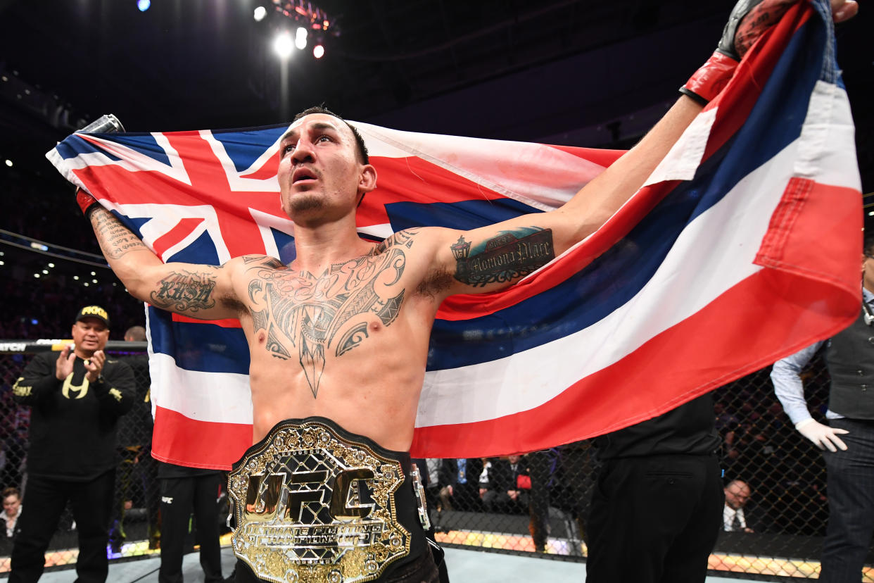 Max Holloway, holding the Hawaii state flag, celebrates his victory over Brian Ortega in their UFC featherweight championship fight at UFC 231 on Dec. 8, 2018 in Toronto, Canada. (Getty Images)