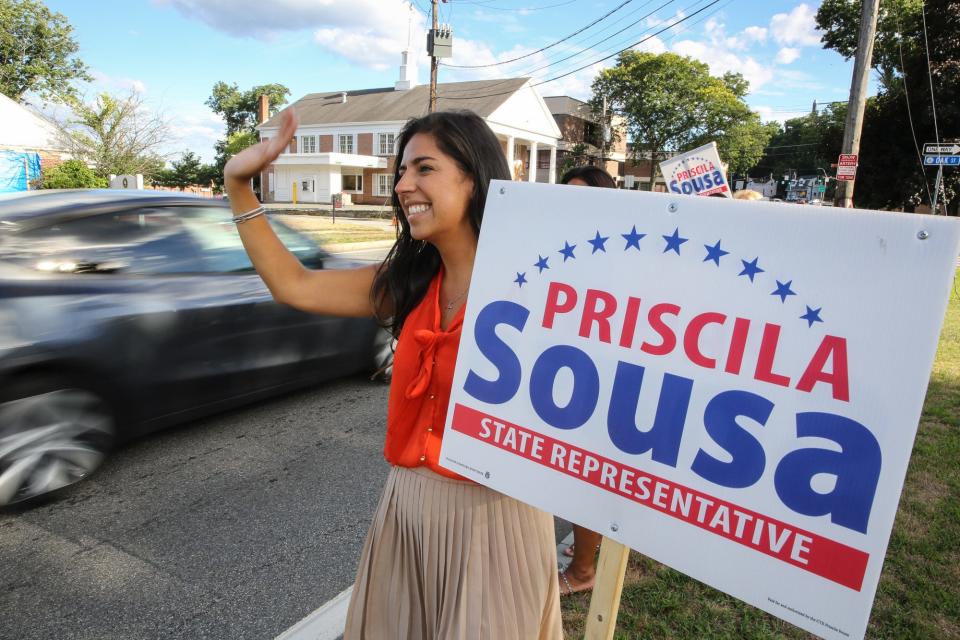 Priscila Sousa, a candidate for the new minority-majority 6th Middlesex district in Framingham, waves to motorists along the Framingham Centre Common, Aug. 12, 2022.