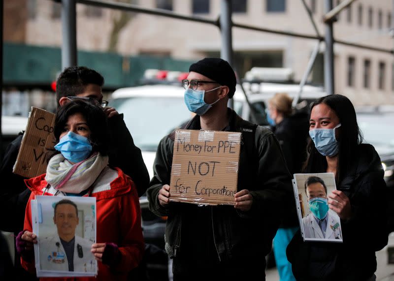 Healthcare workers at Mount Sinai Hospital hold photos of sick colleagues during a protest demanding critical Personal Protective Equipment (PPE) to handle patients during the outbreak coronavirus disease (COVID-19) outbreak, in New York