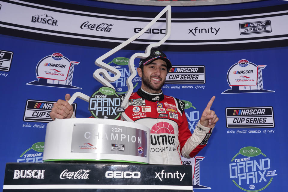 Chase Elliott, left, poses with the trophy in Victory Lane after winning a NASCAR Cup Series auto race at Circuit of the Americas in Austin, Texas, Sunday, May 23, 2021. (AP Photo/Chuck Burton)