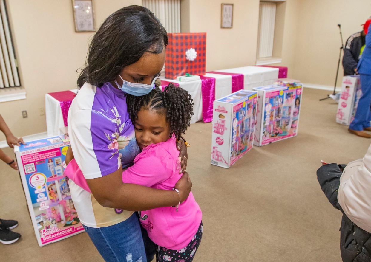 Montanna Jackson, 7, hugs Shanette Smiley, mother of Chrysah Stephens, the 7-year-old girl shot and killed last year while attending a birthday party, at an event where Shanette Smiley helped to give dollhouses to a group of girls.