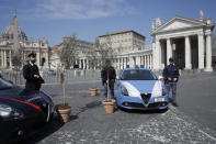 Small olive trees are placed next to the patrol of Italian police in St. Peter's Square at the Vatican as Pope Francis celebrates Palm Sunday Mass behind closed doors at the Vatican, Sunday, April 5, 2020, during the lockdown aimed at curbing the spread of the COVID-19 infection, caused by the novel coronavirus. The new coronavirus causes mild or moderate symptoms for most people, but for some, especially older adults and people with existing health problems, it can cause more severe illness or death. (AP Photo/Alessandra Tarantino)