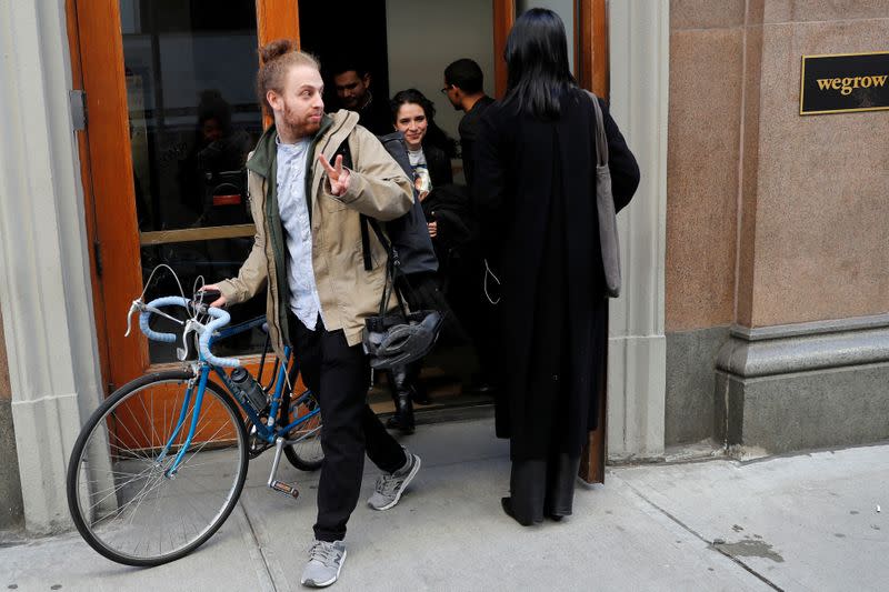 FILE PHOTO: Laid-off WeWork employees exit WeWork corporate headquarters in Manhattan, New York