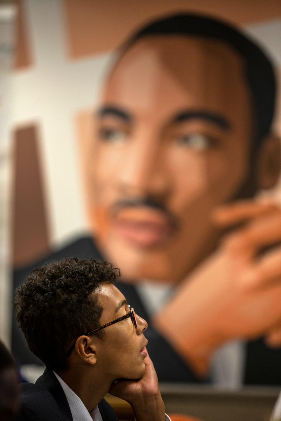 W.E. B DuBois Academy student Del Shawn Cheffen listens during instruction in Chris Rasheed's English language arts class while a large portrait of Dr. Martin Luther King looks over the classroom. Sept. 5, 2019
