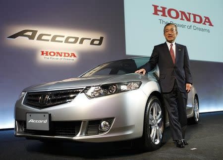 Former Honda Motor Co. President and Chief Executive Officer Takeo Fukui poses with the company's Accord car during its unveiling in Tokyo in this December 4, 2008 file photo. REUTERS/Toru Hanai