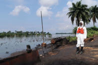 A member of the joint task force, part of the Bodo oil spill clean-up operation, stands near the site of an illegal refinery near the village of Bodo in the Niger Delta, Nigeria August 2, 2018. Picture taken August 2, 2018. REUTERS/Ron Bousso