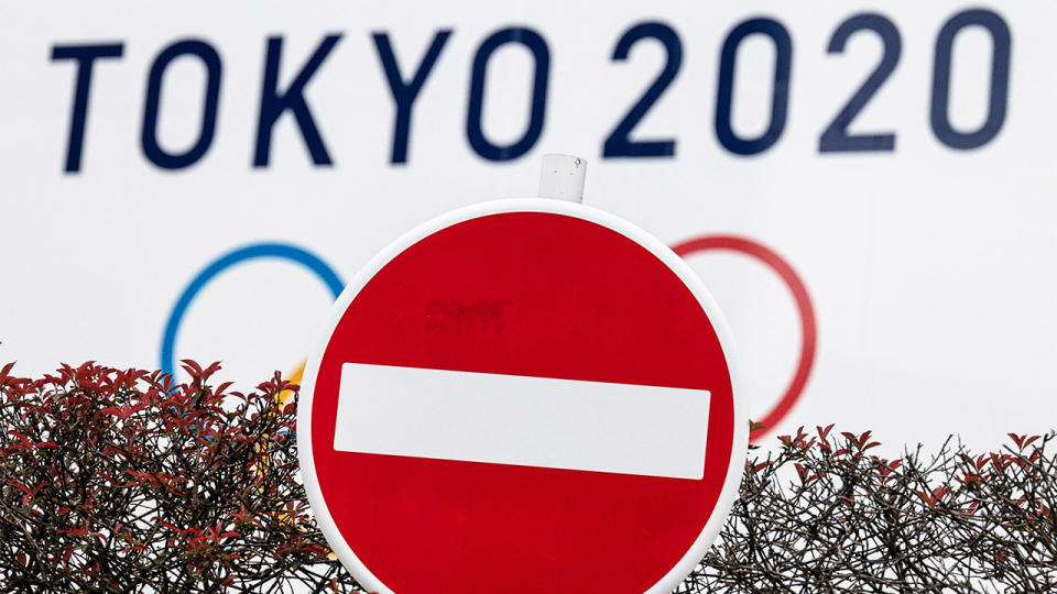 A stop sign in front of the Olympic rings.