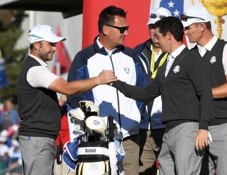 Sep 29, 2016; Chaska, MN, USA; Rory McIlroy of Northern Ireland greets Andy Sullivan of England on the first tee during a practice round for the 41st Ryder Cup at Hazeltine National Golf Club. Mandatory Credit: Michael Madrid-USA TODAY Sports