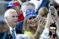 Vice President Mike Pence poses with Paula Tenreiro, who is wearing a cap with the design of the Venezuelan flag, following a tour on the USNS Comfort, Tuesday, June 18, 2019, in Miami. The hospital ship is scheduled to embark on a five-month medical assistance mission to Latin America and the Caribbean, including several countries struggling to absorb migrants from crisis-wracked Venezuela. (AP Photo/Lynne Sladky)